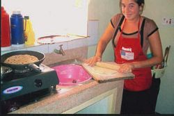 A Volunteer helps in cooking chapatis.